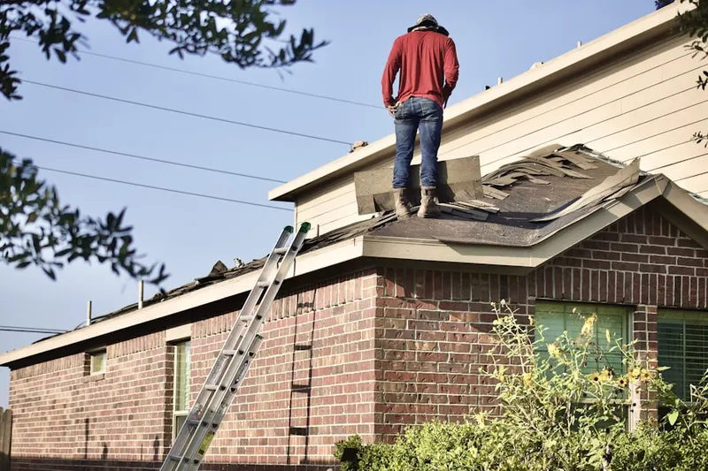 Professional roofer working on a residential roof in Park